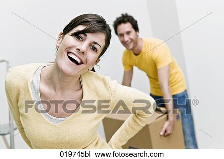 Stock Image - portrait of young woman moving home. Fotosearch