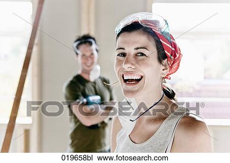 Stock Image - portrait of young woman on construction site of new home. Fotosearch