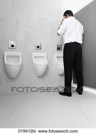 rear view of businessman standing at toilet and talking on mobile phone View Large Photo Image Stock Image - rear view of businessman standing at toilet and talking on mobile phone. Fotosearch