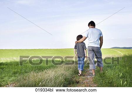 rear view of young father talking to his son in the countryside View Large Photo Image Stock Image - rear view of young father talking to his son in the countryside. Fotosearch