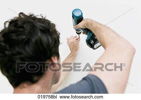 rear view of young man using cordless screwdriver View Large Photo Image Stock Image - rear view of young man using cordless screwdriver. Fotosearch