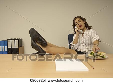 secretary sitting at desk talking on the telephone with her legs up View Large Photo Image Stock Image - secretary sitting at desk talking on the telephone with her legs up. Fotosearch
