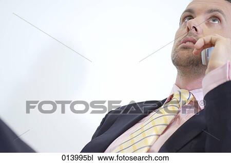 serious male executive having phone conversation looking up View Large Photo Image Stock Image - serious male executive having phone conversation looking up. Fotosearch