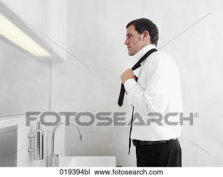 side view of businessman putting on his tie View Large Photo Image Stock Image - side view of businessman putting on his tie. Fotosearch