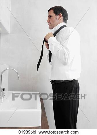 side view of businessman putting on his tie View Large Photo Image Stock Image - side view of businessman putting on his tie. Fotosearch