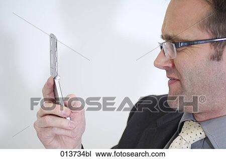 side view of businessman with spectacles checking mobile for text messages View Large Photo Image Stock Image - side view of businessman with spectacles checking mobile for text messages. Fotosearch