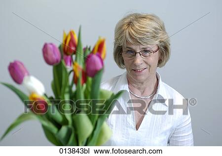 smiling mature woman with bunch of tulips View Large Photo Image Stock Image - smiling mature woman with bunch of tulips. Fotosearch
