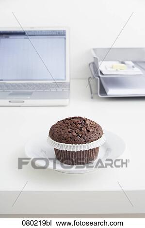 still life of chocolate muffin on plate on office desk View Large Photo Image Stock Image - still life of chocolate muffin on plate on office desk. Fotosearch
