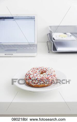 still life of donut on plate on office desk View Large Photo Image Stock Image - still life of donut on plate on office desk. Fotosearch