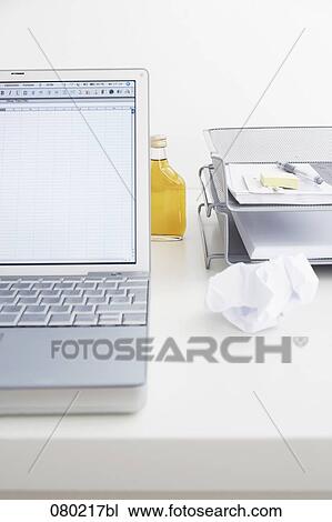 still life of little alcohol bottle hidden behind laptop computer on office desk View Large Photo Image Stock Image - still life of little alcohol bottle hidden behind laptop computer on office desk. Fotosearch