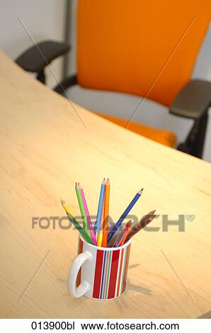Stock Image - still life of office desk and chair with pencils in cup. Fotosearch