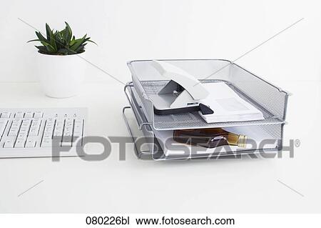 still life of small alcohol bottle hidden in tray on office desk View Large Photo Image Stock Image - still life of small alcohol bottle hidden in tray on office desk. Fotosearch