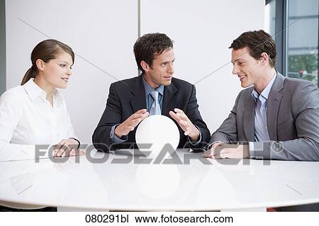 three business people sitting around table looking at crystal ball View Large Photo Image Stock Image - three business people sitting around table looking at crystal ball. Fotosearch