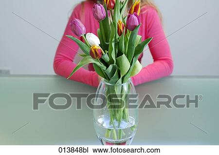 tulips in vase with woman sitting behind View Large Photo Image Stock Image - tulips in vase with woman sitting behind. Fotosearch