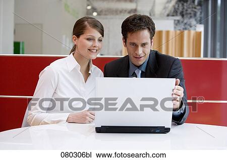 two business people working at laptop together View Large Photo Image Stock Image - two business people working at laptop together. Fotosearch