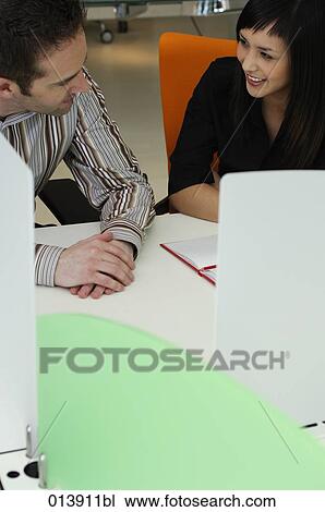 two office workers smiling at each other View Large Photo Image Stock Image - two office workers smiling at each other. Fotosearch