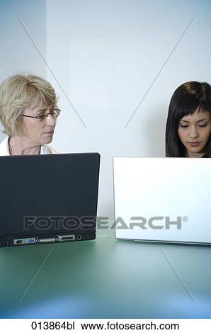 two woman working with notebook computers View Large Photo Image Stock Image - two woman working with notebook computers. Fotosearch