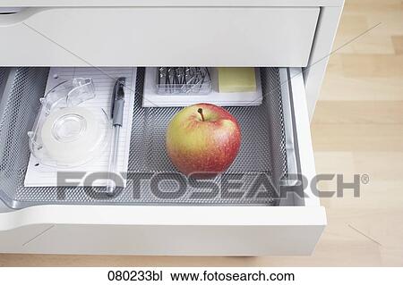 view into open desk drawer containing red apple View Large Photo Image Stock Image - view into open desk drawer containing red apple. Fotosearch