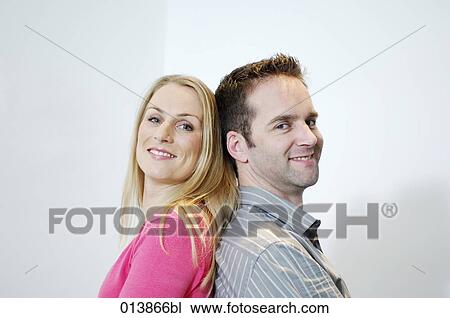 woman and man sitting back to back smiling View Large Photo Image Stock Image - woman and man sitting back to back smiling. Fotosearch