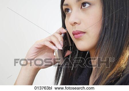 young asian woman with thoughtful expression having telephone conversation View Large Photo Image Stock Image - young asian woman with thoughtful expression having telephone conversation. Fotosearch
