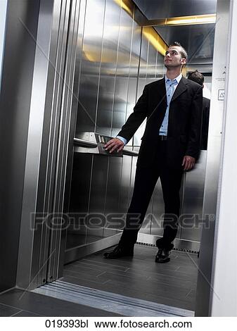 young businesman standing in elevator View Large Photo Image Stock Image - young businesman standing in elevator. Fotosearch