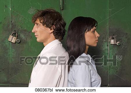young businessman and businesswoman standing back to back in front of lockers View Large Photo Image Stock Image - young businessman and businesswoman standing back to back in front of lockers. Fotosearch