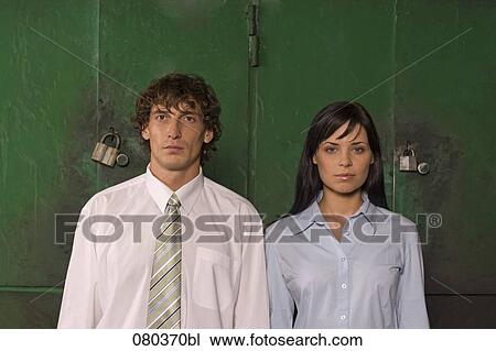 Stock Image - young businessman and businesswoman standing side by side. Fotosearch
