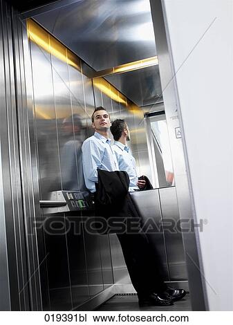 young businessman standing in elevator View Large Photo Image Stock Image - young businessman standing in elevator. Fotosearch