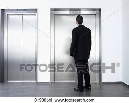 young businessman standing in front of elevator View Large Photo Image Stock Image - young businessman standing in front of elevator. Fotosearch