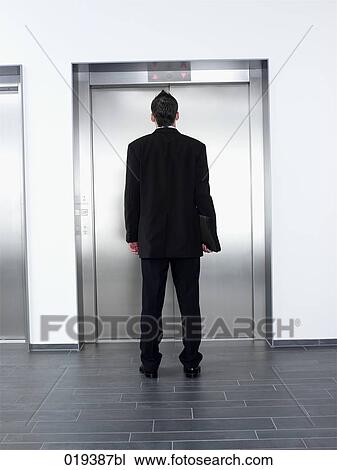 young businessman standing in front of elevator View Large Photo Image Stock Image - young businessman standing in front of elevator. Fotosearch