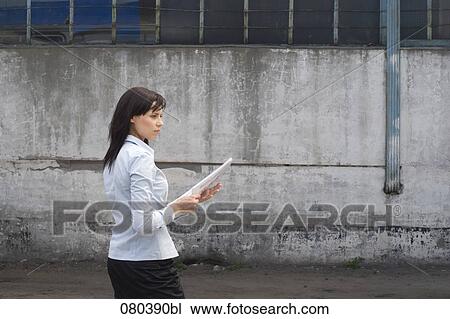 young businesswoman standing in front of factory building holding plan in hands View Large Photo Image Stock Image - young businesswoman standing in front of factory building holding plan in hands. Fotosearch