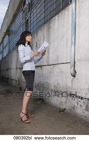 young businesswoman standing in front of factory building holding plan in hands View Large Photo Image Stock Image - young businesswoman standing in front of factory building holding plan in hands. Fotosearch