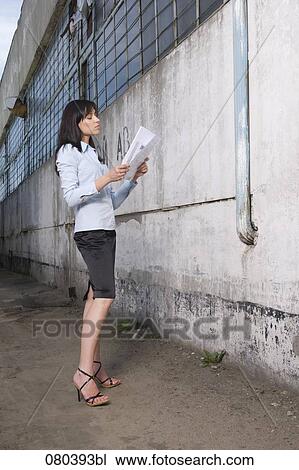 young businesswoman standing in front of factory building holding plan in hands View Large Photo Image Stock Image - young businesswoman standing in front of factory building holding plan in hands. Fotosearch