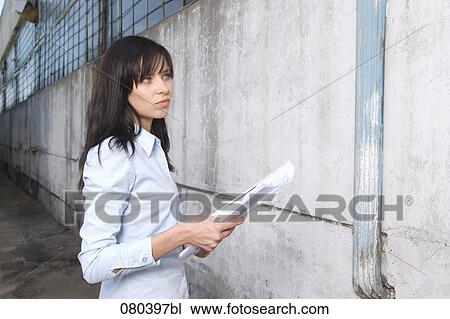 young businesswoman standing in front of factory building holding plan in hands View Large Photo Image Stock Image - young businesswoman standing in front of factory building holding plan in hands. Fotosearch