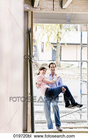 young carrying his wife into new home View Large Photo Image Stock Image - young carrying his wife into new home. Fotosearch