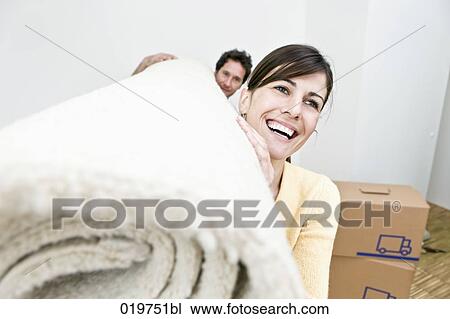 young couple carrying carpet into their new home View Large Photo Image Stock Image - young couple carrying carpet into their new home. Fotosearch