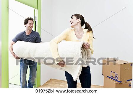 young couple carrying carpet into their new home View Large Photo Image Stock Image - young couple carrying carpet into their new home. Fotosearch