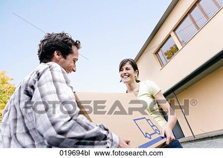 young couple carrying moving box into their new home View Large Photo Image Stock Image - young couple carrying moving box into their new home. Fotosearch