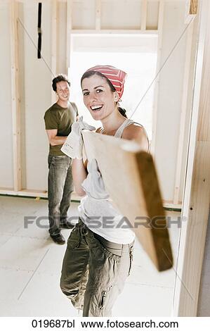 young couple carrying wooden plank on construction site View Large Photo Image Stock Image - young couple carrying wooden plank on construction site. Fotosearch