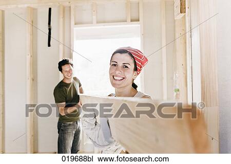 young couple carrying wooden plank on construction site View Large Photo Image Stock Image - young couple carrying wooden plank on construction site. Fotosearch
