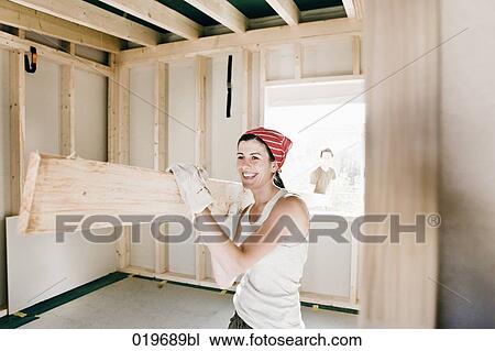 young couple carrying wooden plank on construction site View Large Photo Image Stock Image - young couple carrying wooden plank on construction site. Fotosearch