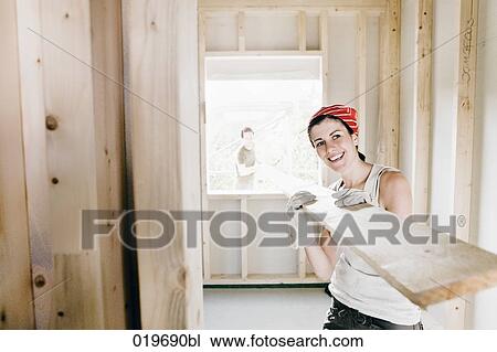 young couple carrying wooden plank on construction site View Large Photo Image Stock Image - young couple carrying wooden plank on construction site. Fotosearch