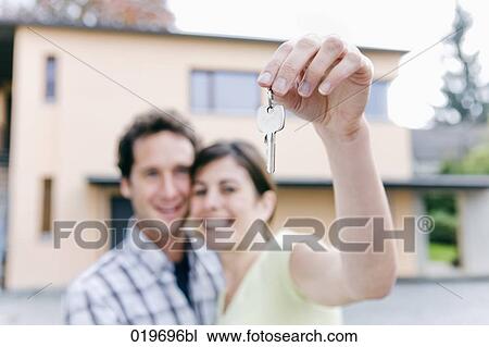 young couple holding the keys to their new home View Large Photo Image Stock Image - young couple holding the keys to their new home. Fotosearch