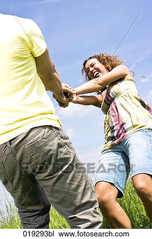 young couple playing withj each other on meadow View Large Photo Image Stock Image - young couple playing withj each other on meadow. Fotosearch