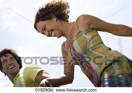 young couple walking hand in hand through meadow View Large Photo Image Stock Image - young couple walking hand in hand through meadow. Fotosearch