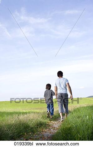 young father and his son walking on path in the countryside View Large Photo Image Stock Image - young father and his son walking on path in the countryside. Fotosearch