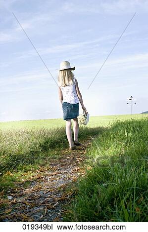 young girl with basket full of flowers walking on path in the countryside View Large Photo Image Stock Image - young girl with basket full of flowers walking on path in the countryside. Fotosearch