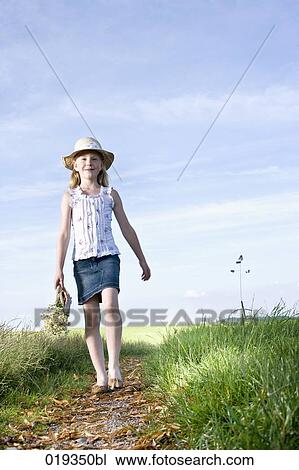young girl with basket full of flowers walking on path in the countryside View Large Photo Image Stock Image - young girl with basket full of flowers walking on path in the countryside. Fotosearch