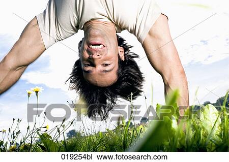 young man doing handstand on grass View Large Photo Image Stock Image - young man doing handstand on grass. Fotosearch