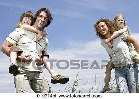 young parents giving their children piggyback ride View Large Photo Image Stock Image - young parents giving their children piggyback ride. Fotosearch